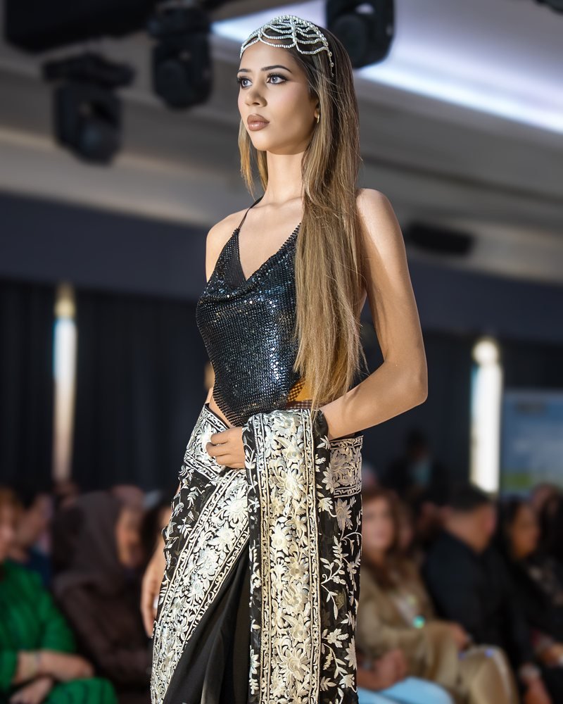 A model on the runway in a jewelled headpiece with sleek styling and full bridal make-up