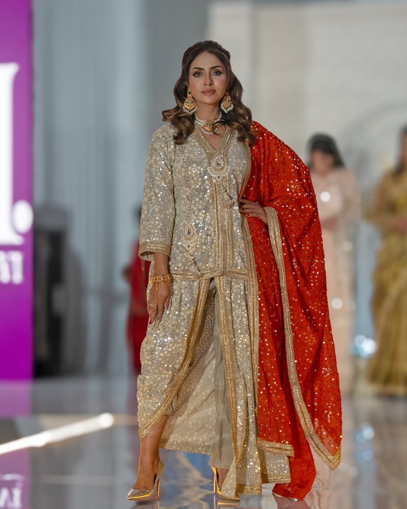 A model in a gold sequinned sharara set with a red embellished dupatta